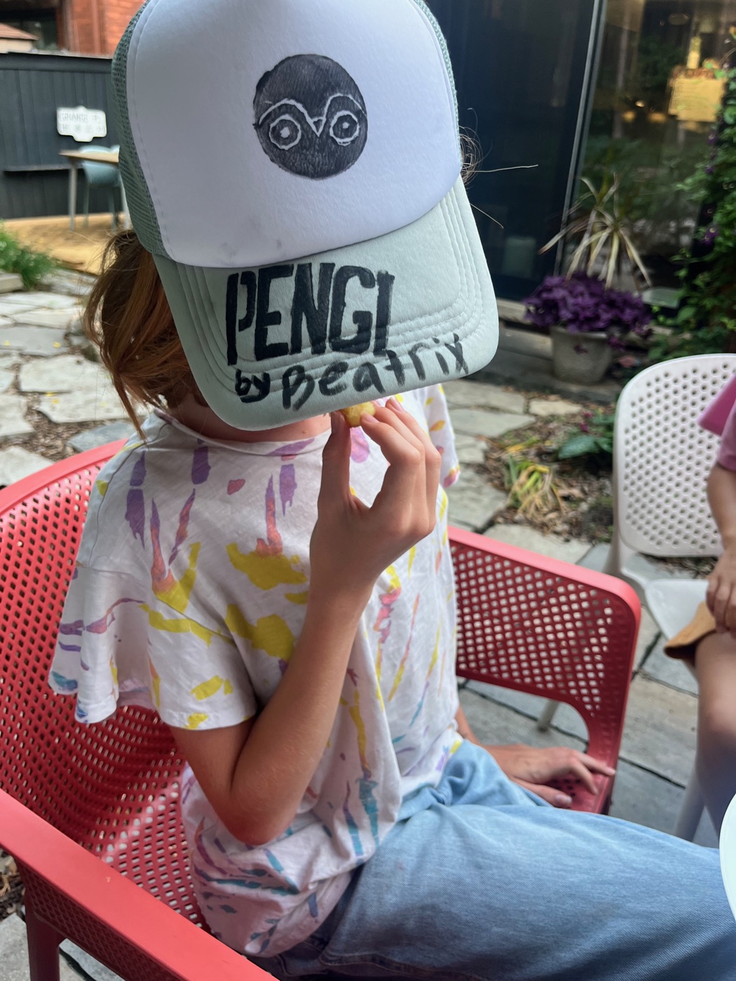 Kid wearing Pengi trucker hat, face covered